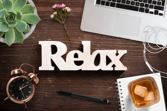Wort "relax" auf Holzuntergrund und Bürodekoration