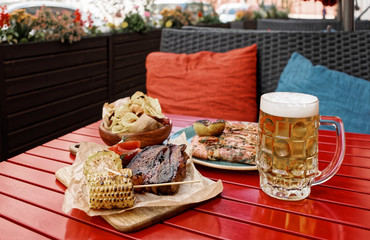 Beer and savory food on table, toned