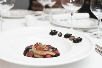Foie gras with port sauce on table, toned