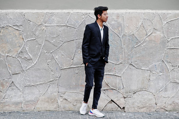 Young indian man on suit and glasses posed outdoor.