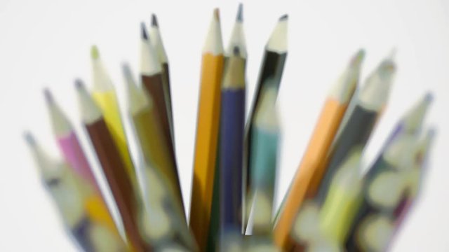 Pencil on a white background. Camera in motion. Pencils are in the glass