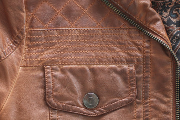 Button pocket on leather jacket. The jacket fastens with a zipper. Background.