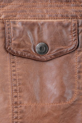 button pocket on old worn leather jacket. background