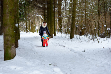 Fototapeta na wymiar family walk in the winter forest dad mom and child