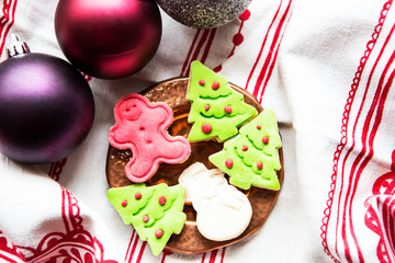 galletas de navidad en forma de arbol de navidad verde y muñeco de nieve, con bolas de navidad como decoración
