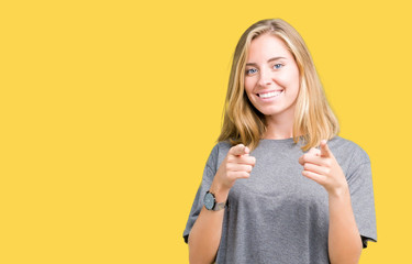 Beautiful young woman wearing oversize casual t-shirt over isolated background pointing fingers to camera with happy and funny face. Good energy and vibes.