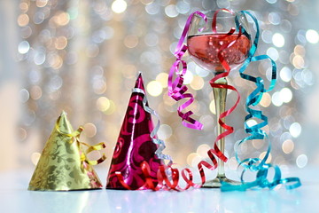 Celebrating New Years with glass of rose sparkling wine and party hats