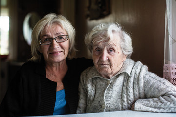 Portrait of old woman with her adult daughter.