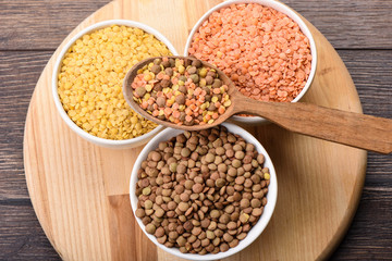 Assorted varieties of lentils on a wooden background