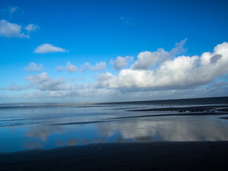 Beautiful cloud reflections on Westward Ho beach in Devon , England
