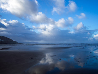 Fototapeta na wymiar beautiful cloud reflections on the sands of Westward ho beach in Devon ,England