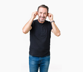 Fototapeta premium Handsome middle age hoary senior man over isolated background Smiling pulling ears with fingers, funny gesture. Audition problem