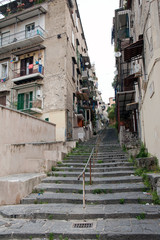 Fototapeta na wymiar Alley with staircase paved with lava stones in the populated suburb called 
