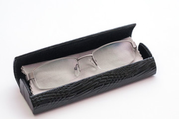 Glasses and case with glasses cleaning cloth on white background