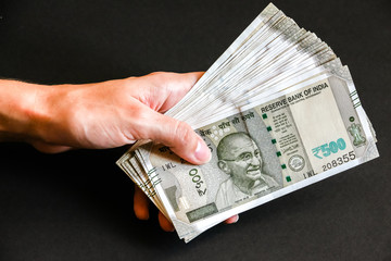 Woman's hands holding brand new indian 500 rupees banknotes.