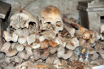 A heap of bones and skulls placed against the walls bones inside an ancient underground cemetery commonly named “Fontanelle” in Naples, Italy