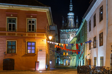 Night scene with the tower clock of the medieval town of Sighisoara, in Romania