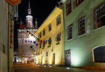 Night scene with the tower clock of the medieval town of Sighisoara, in Romania