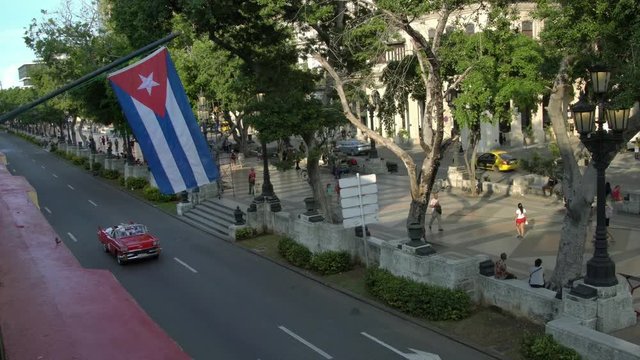 Classic american cars on the street in Havana seen from above, cuban flag in La Habana, Cuba