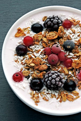 Colorful healthy breakfast bowl with berries, yogurt and granola. Top view.