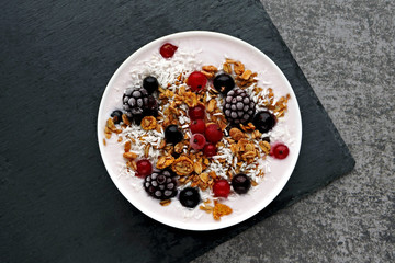 Colorful healthy breakfast bowl with berries, yogurt and granola. Top view.