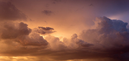 Fototapeta na wymiar Backlit gray clouds glowing over the desert