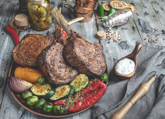 Grilled lamb, beef meat chops with vegetables on the plate. Rustic food concept