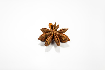 Single anise star isolated on white reflective surface