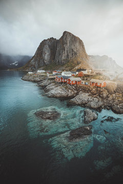 A small town by the river with mountains in the distance