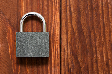 Fototapeta premium Padlock for security on wooden background. Check-lock on the brown wooden table background