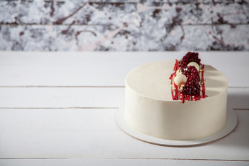 Fototapeta na wymiar Beautiful white cake decorated with red berries.