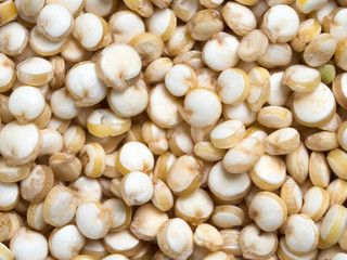 Grain of quinoa extreme closeup. Uncooked raw quinoa as background. Healthy vegan food concept and pattern