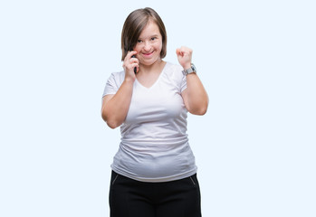 Young adult woman with down syndrome taking using smartphone over isolated background screaming...
