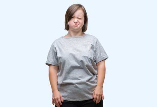 Young adult woman with down syndrome over isolated background winking looking at the camera with sexy expression, cheerful and happy face.