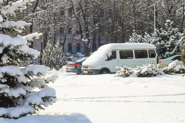City street and cars in the parking lot, covered with fresh white snow, winter landscape of the Dnipro city, Dnepropetrovsk, Dnipropetrovsk,  Ukraine
