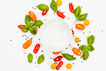 Basil, pepper and cherry tomatoes with empty white bowl in the center, on white background