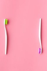 Daily oral hygiene for family. Toothbrush on pink background top view space for text