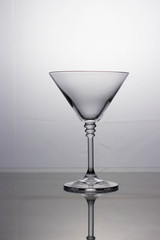 Empty transparent cocktail glass on a light background