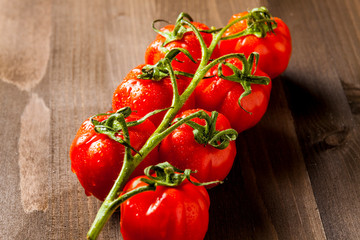 Red cherry tomates on brown cuting board