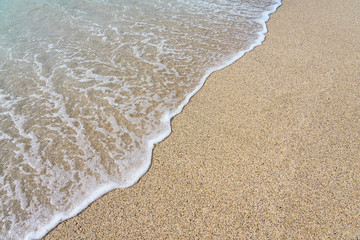  White foam on a sandy beach. Copy space.