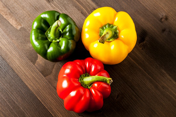 Fresh bell peppers isolated on wooden cutting board