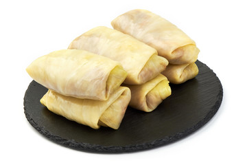 Stuffed cabbage leaves with meat on a slate shale plate, isolated on a white background. Close-up