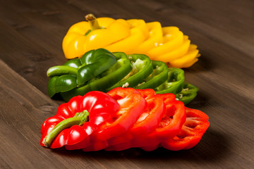 Fresh bell pepper slices isolated on wooden cutting board