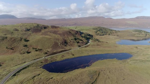 Aerial view oversmall lock near Loch Hope, Scotland. A white camper van can be seen on the road below.