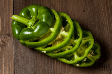 Fresh bell pepper slices isolated on wooden cutting board