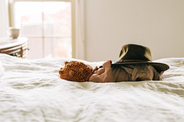 Baby Laying On A Bed With Knit Hat