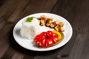 Chinese food on a white plate with rice, paprika and chicken 