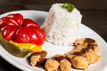 Chinese food on a white plate with rice, paprika and chicken 