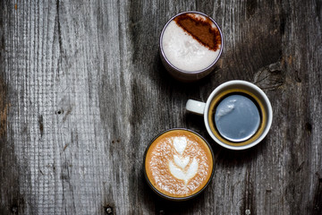 Collage of cups with tasty coffee on wood rustic background