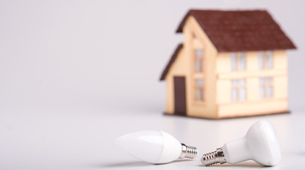 Led lamps lie near the house layout on a white background. Theme energy saving in the house 